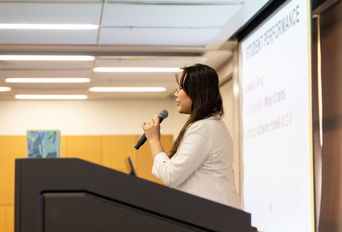 A student speaks into a microphone out into a crowd, presenting on topics explored in the certificate in Asian Studies.