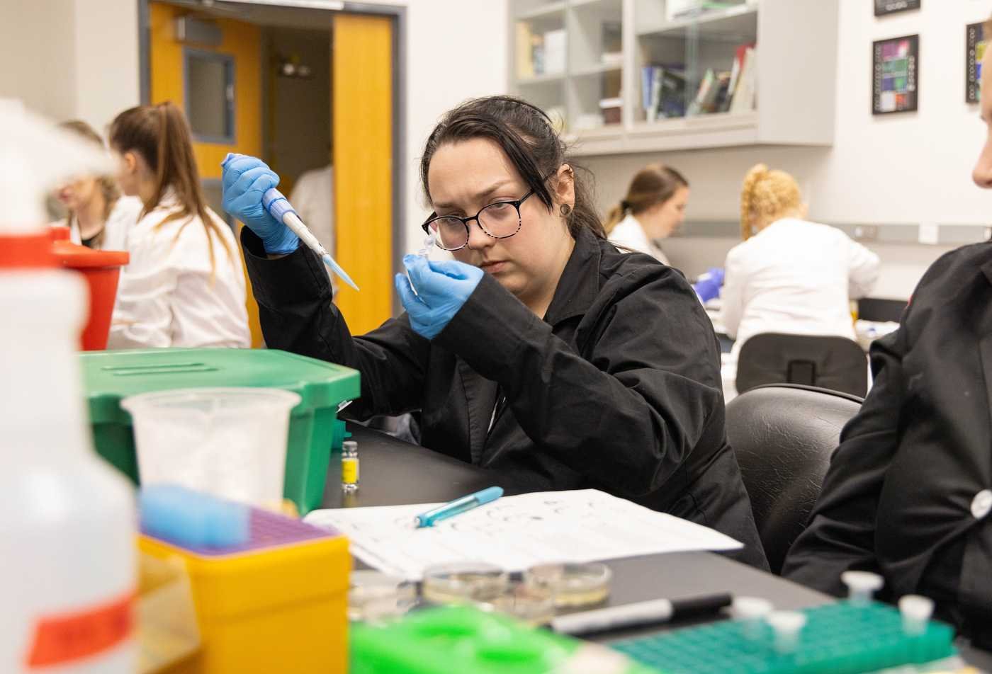 Students conduct experiments in a lab, reflecting hands-on research in the PhD in Biology (Biology and Society).