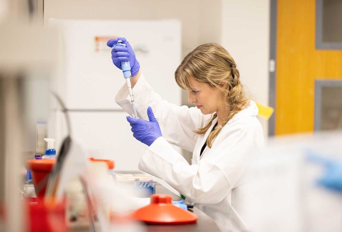 A researcher uses a pipette in a lab, reflecting hands-on discovery in the BS in Biological Sciences (Biomedical Sciences).