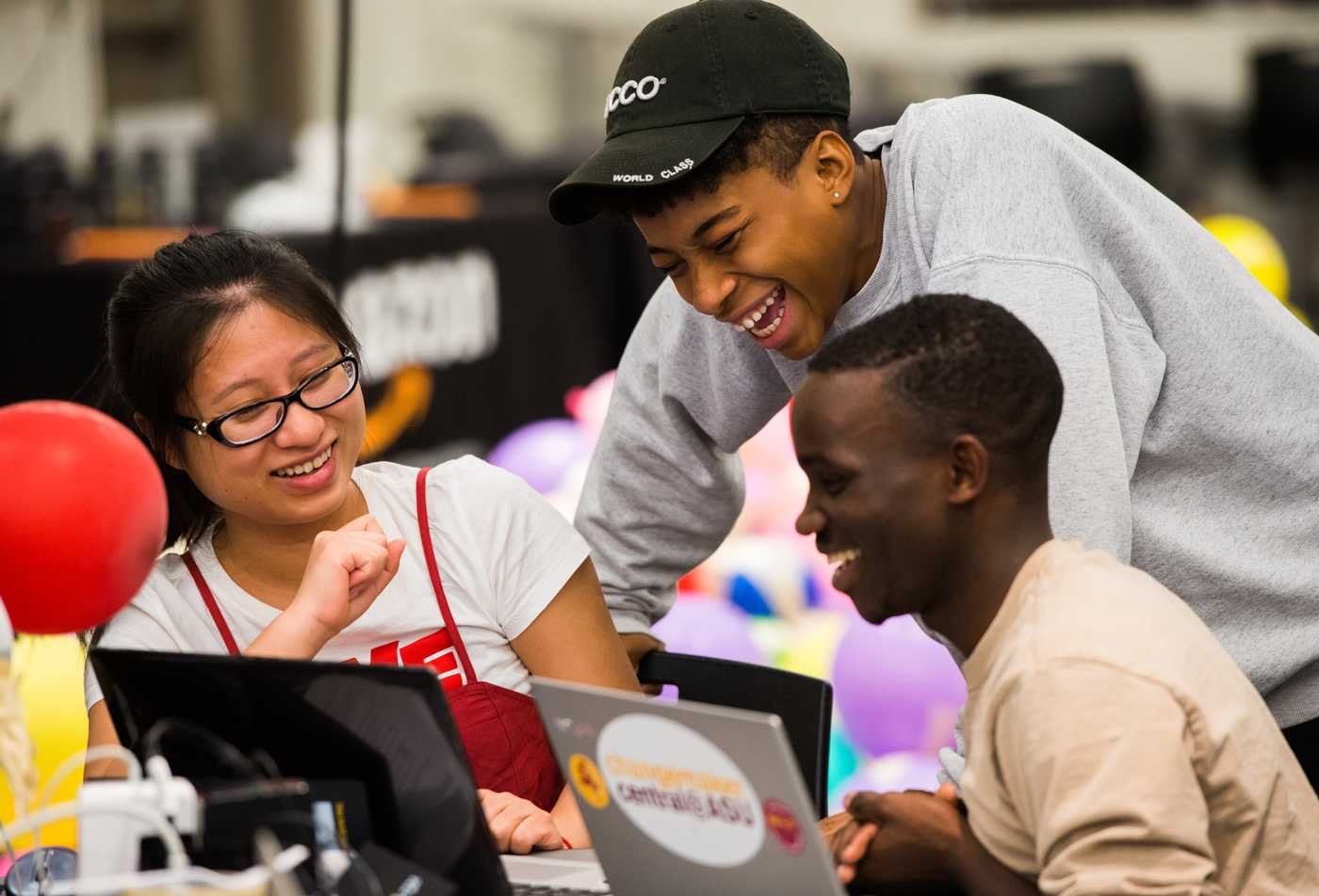Students collaborate on a laptop together, reflecting teamwork in the certificate in Digital Humanities.