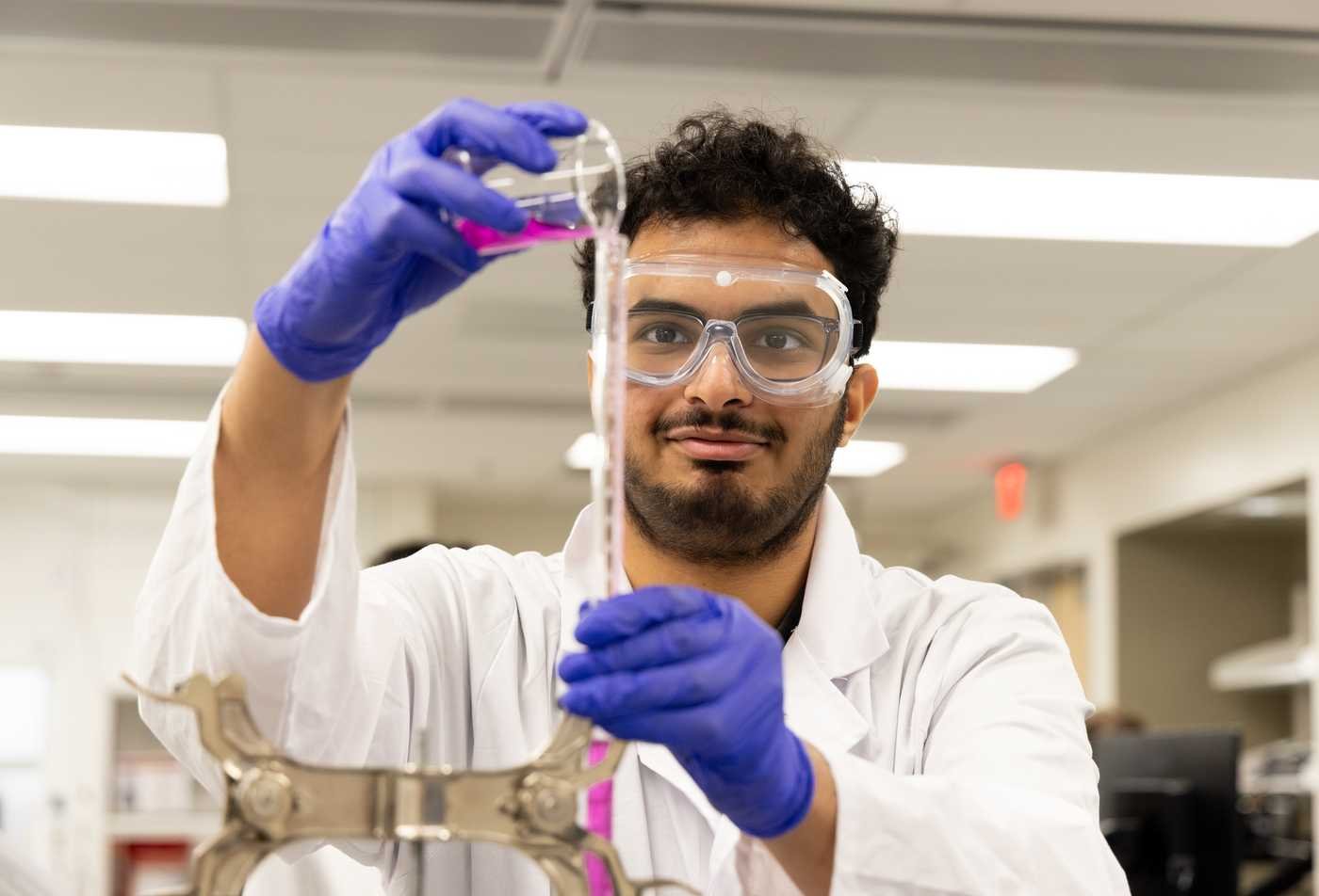 A student conducts a chemistry experiment with lab equipment, building practical skills in ASU's Chemistry, BS program.