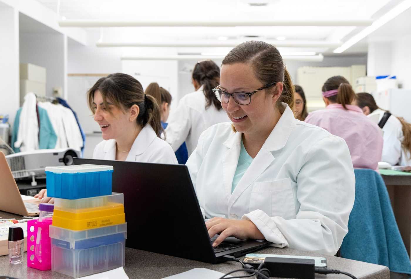 Two female students in the School of Life Sciences work together in a science lab, building hands-on research skills in the certificate in Computational Life Sciences.