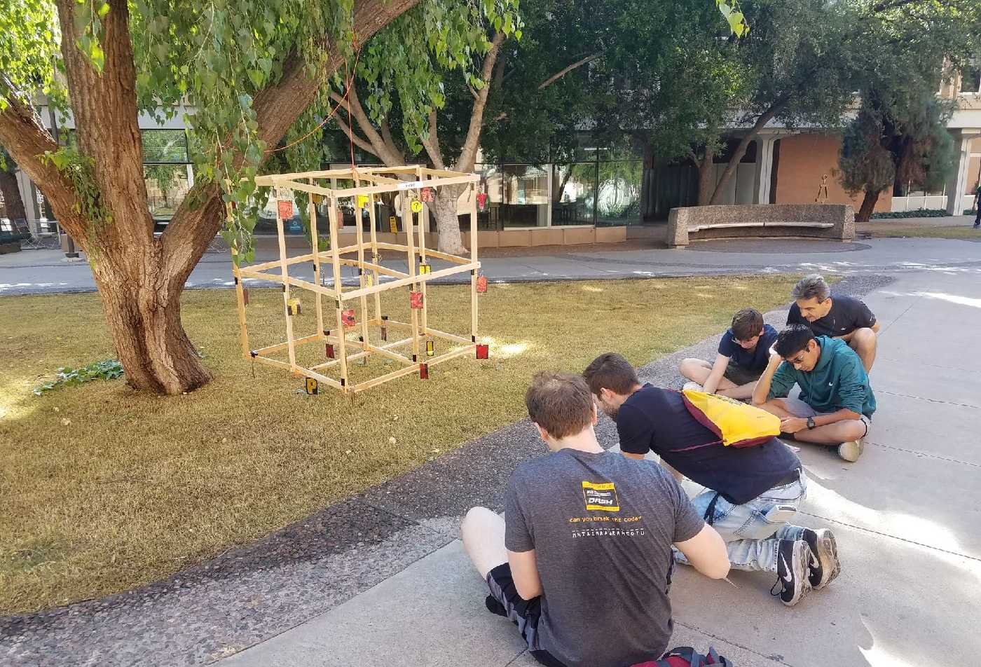 Five students work on a structural project outdoors, demonstrating hands-on learning in the certificate in Cryptology