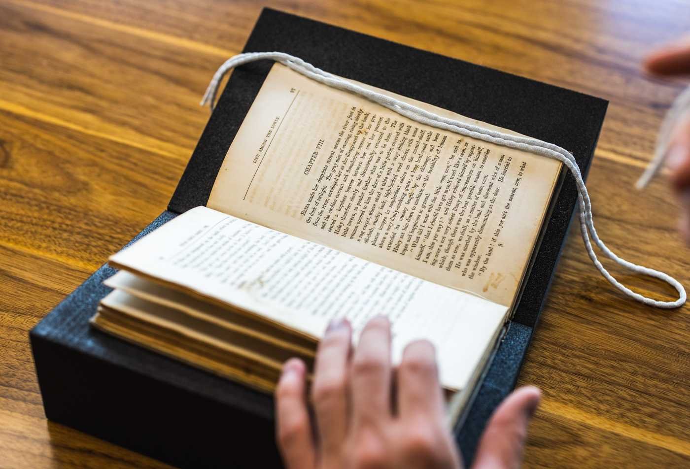 A student examines a historical book from the ASU archive, reflecting engagement with historical inquiry in the certificate in Civic Education.