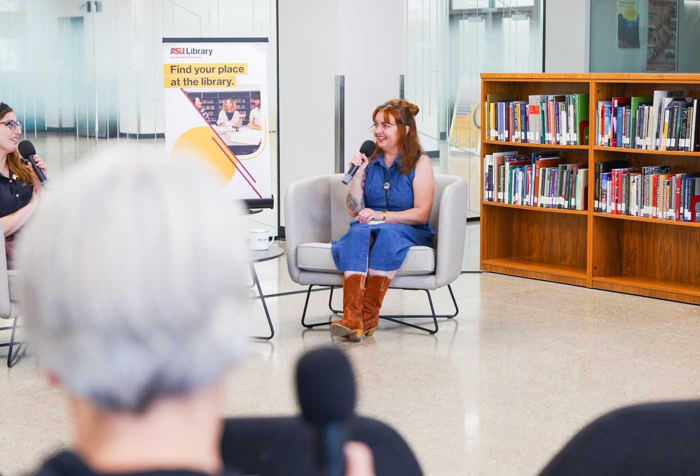 Two women sit in an interview set up inside Hayden Library, highlighting the field explored in the MFA in Creative Writing.