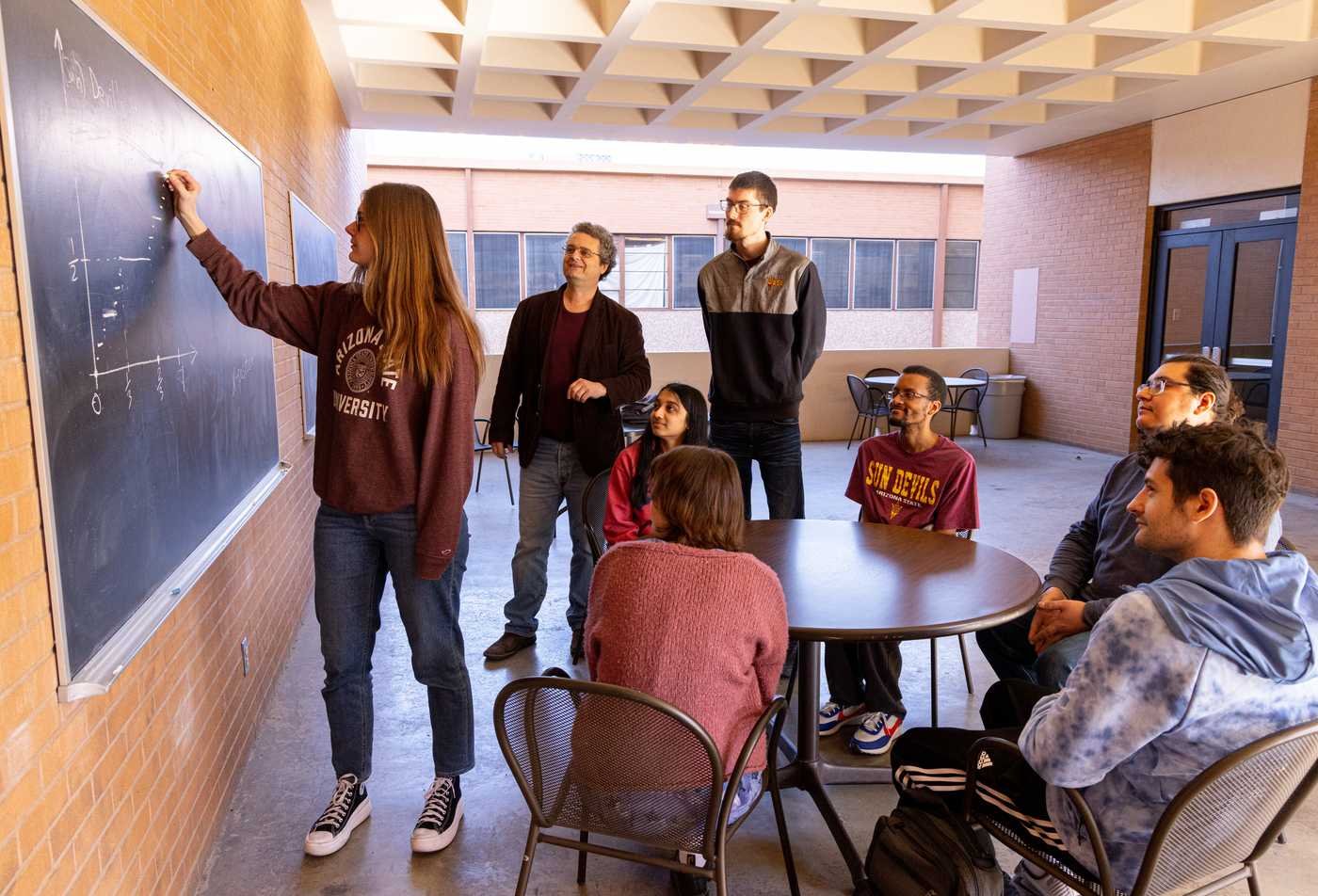 Students solve equations at a chalkboard, building analytical skills in ASU's Data Science, BS program.