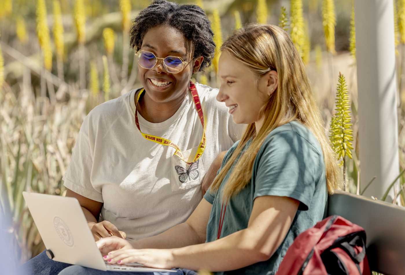 Students write notes on a laptop while outside, reflecting the field of Environmental Communication and Leadership.
