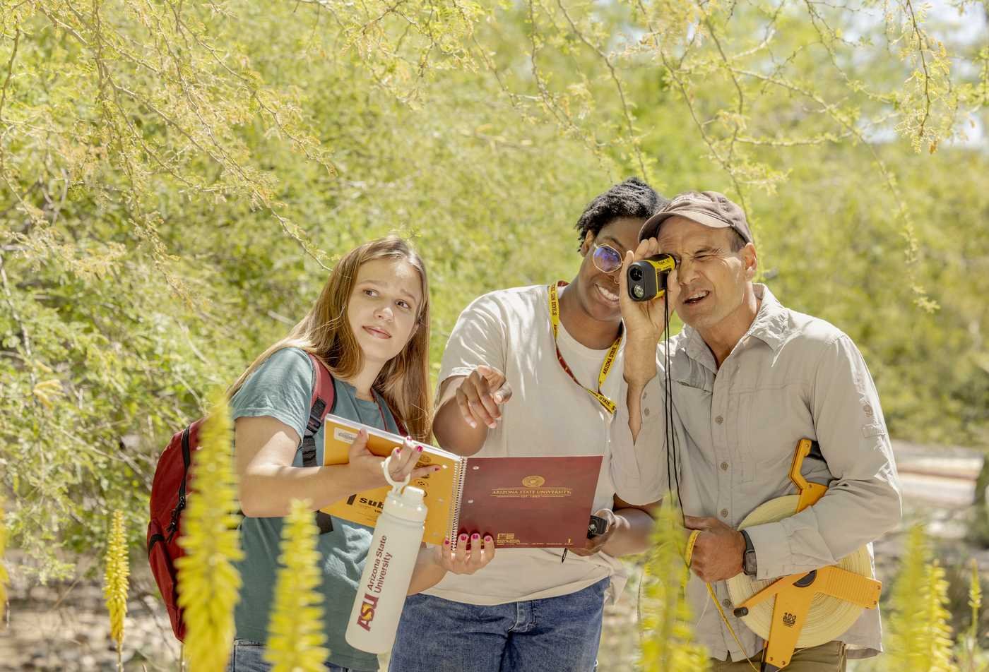 Students take notes in an outdoor environment, reflecting the field explored in the Environmental Life Sciences, PhD