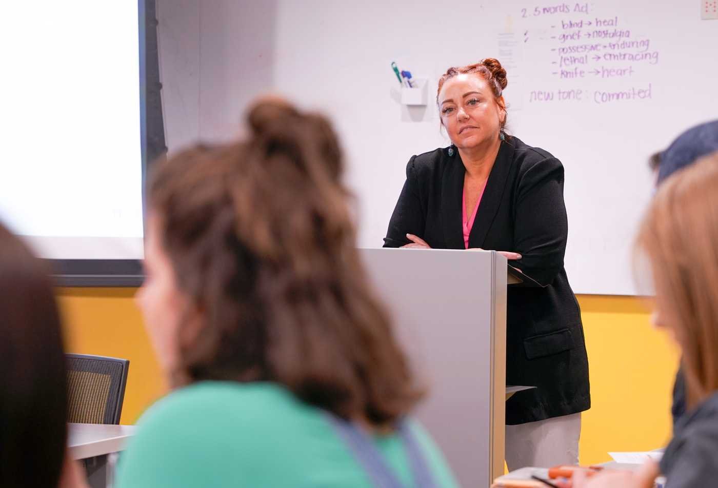 An instructor looks out over students engaging classroom discussion, building communication skills in the English (English Education), PhD.