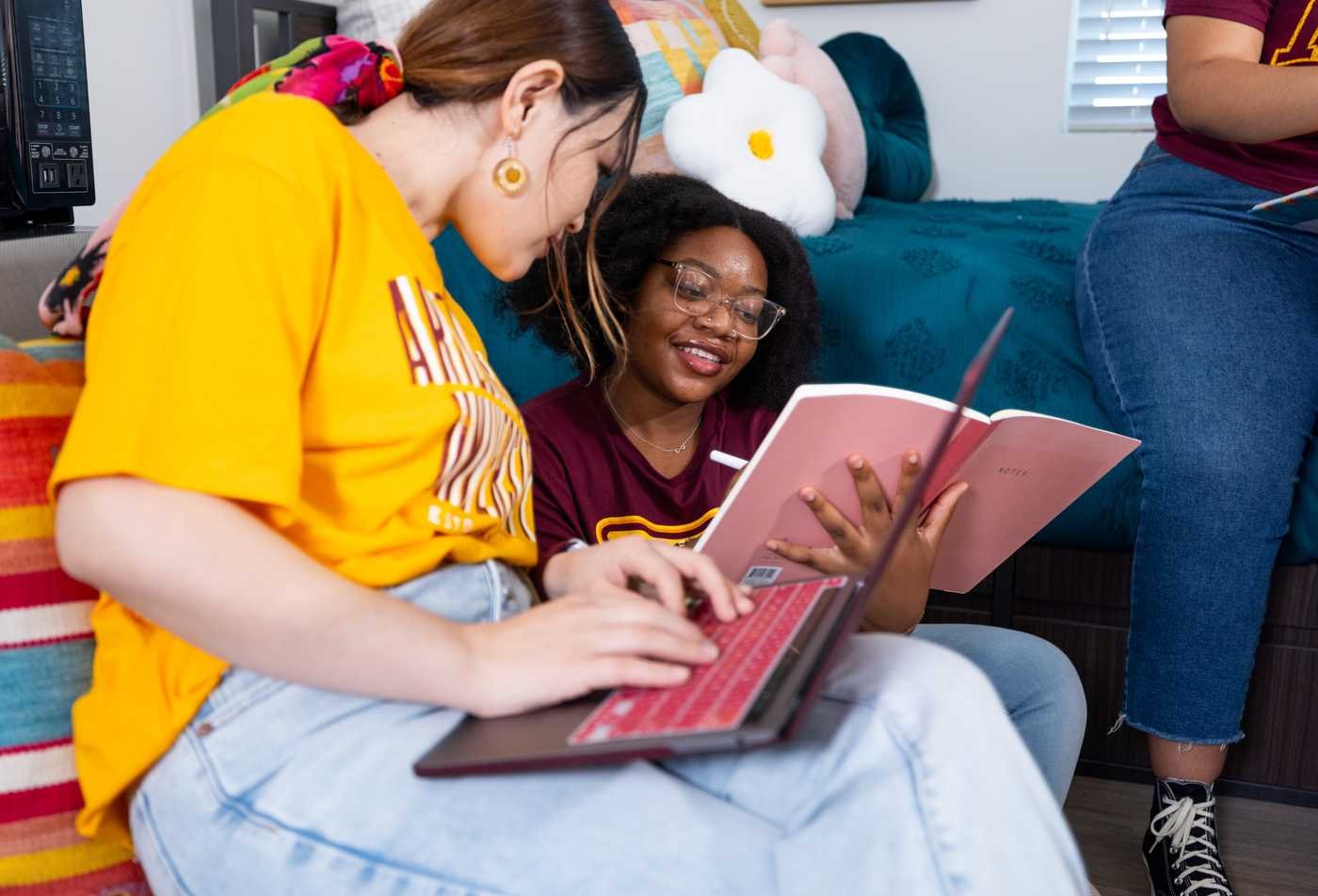 Students study together with a laptop and book, reflecting literary learning in ASU's English, BA program.