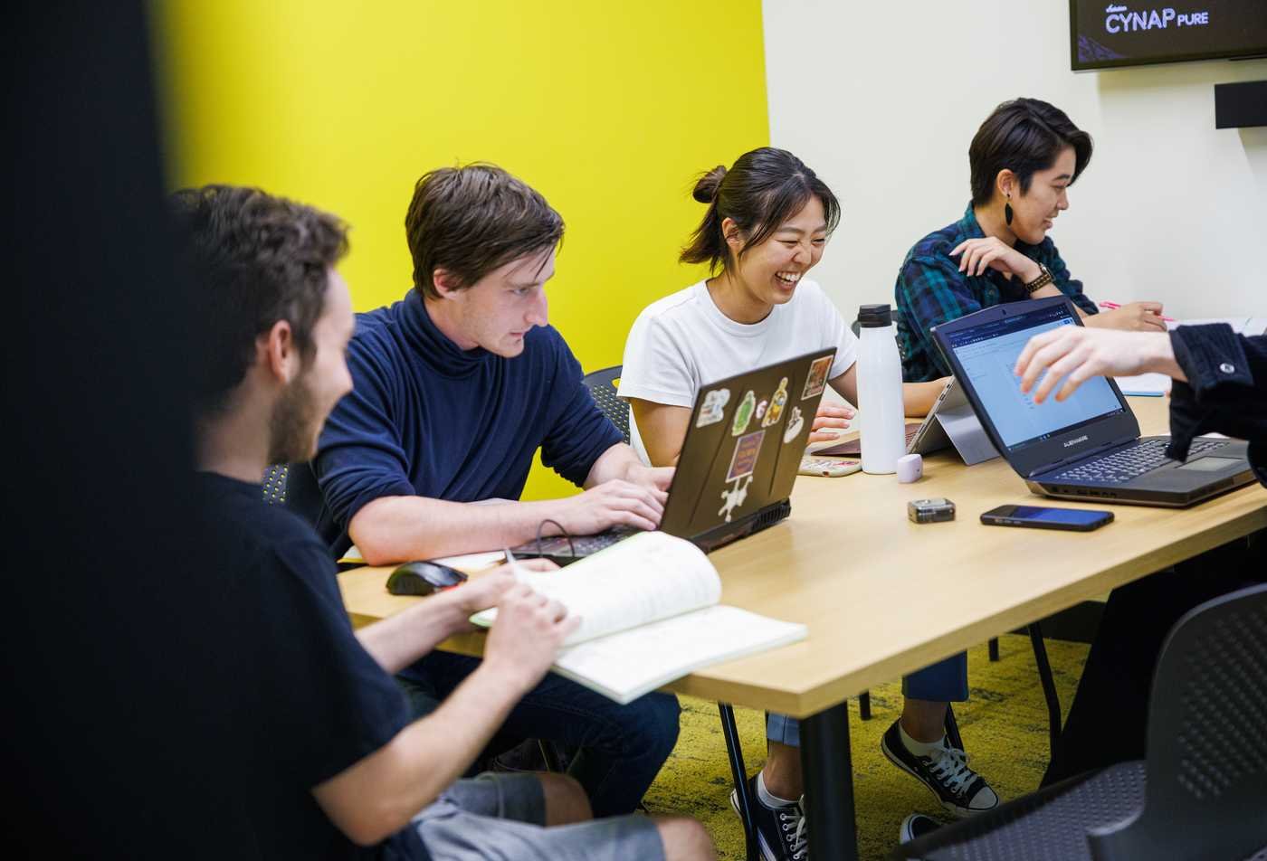 Students collaborate around laptops, exploring language and communication in ASU's English (Linguistics), BA program.