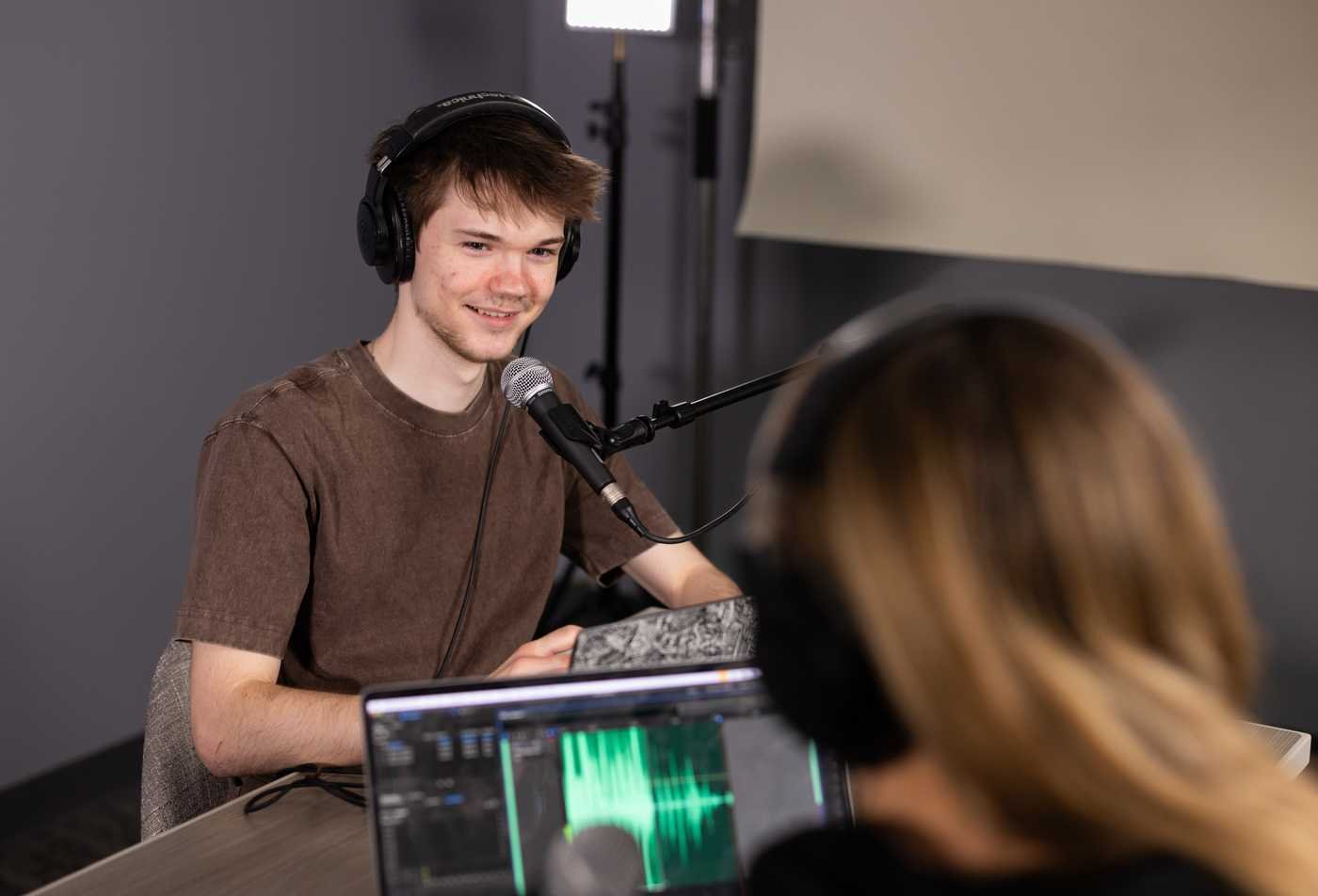 A student speaks into a microphone during a recording, developing storytelling in ASU's English (Narrative Studies), BA program.