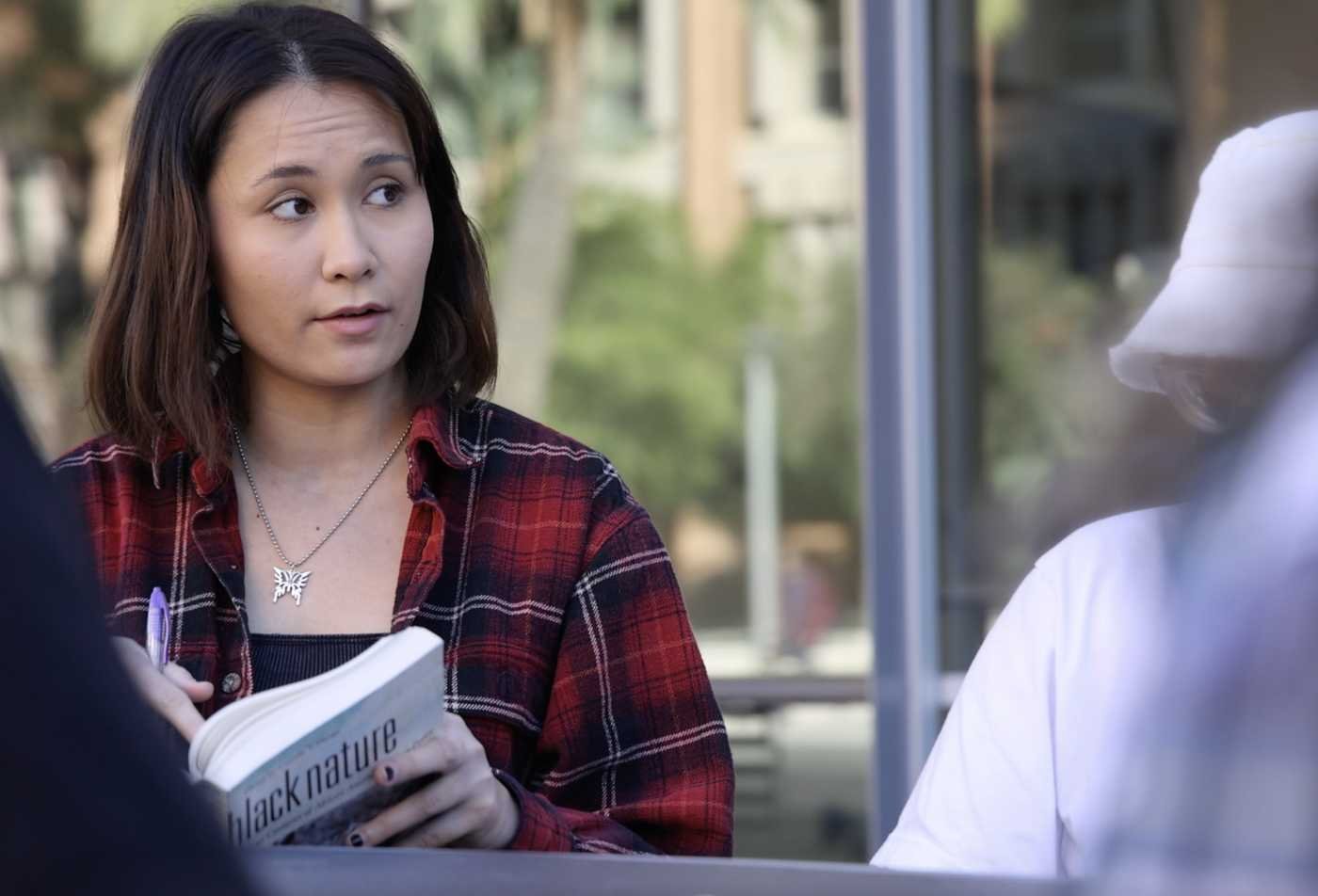 A student discusses a book with classmates, exploring literary analysis in ASU's English (Literature), BA program.