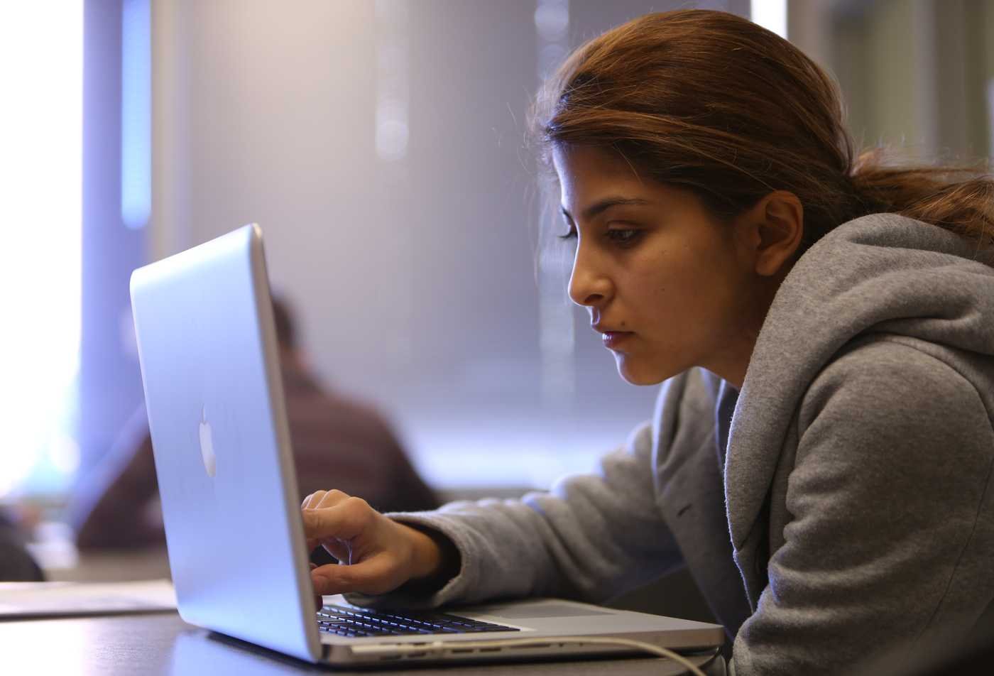 A student examines a laptop, showcasing the flexible coursework in the Exploration Systems Design (Instrumentation), MS
