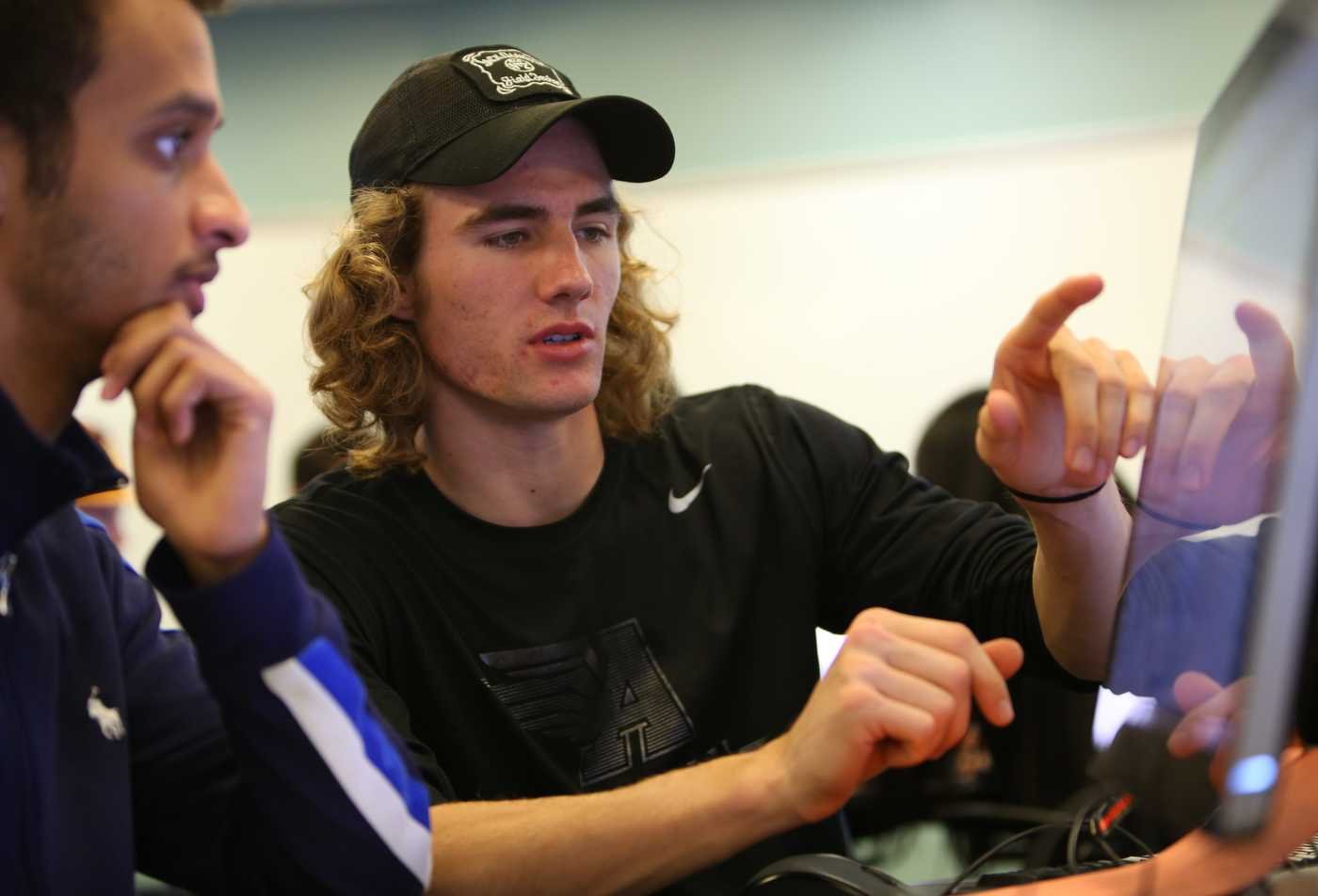 Two students review information together on a computer screen, showcasing collaboration in the Exploration Systems Design (Systems Engineering), PhD.