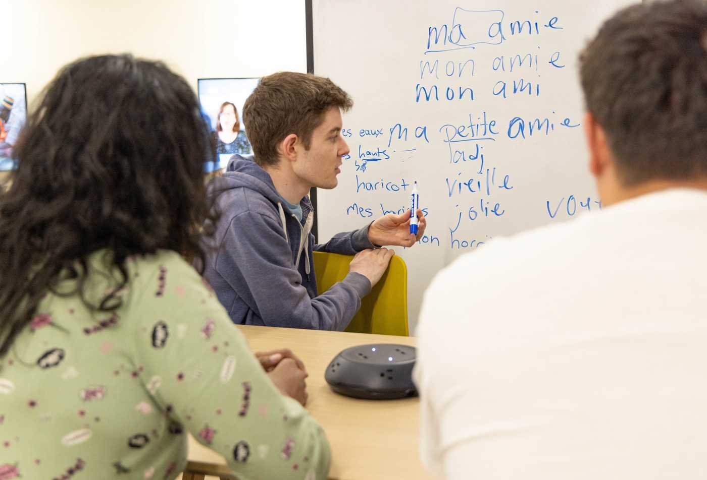 Students practice French at a whiteboard, building language skills in ASU's French, BA program.