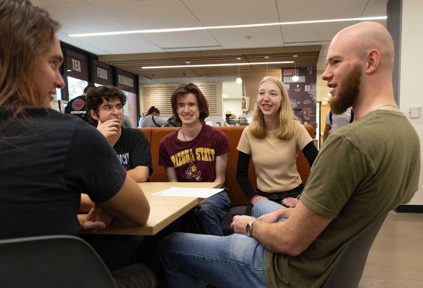Students discuss ideas around a table, exploring global perspectives in ASU's Global Citizenship, BA program.