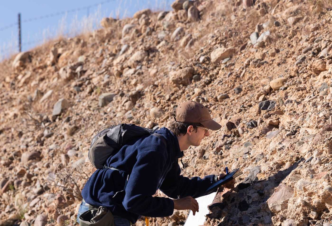 A student examines rock formations in the field during hands-on research ing the Geological Sciences, PhD.