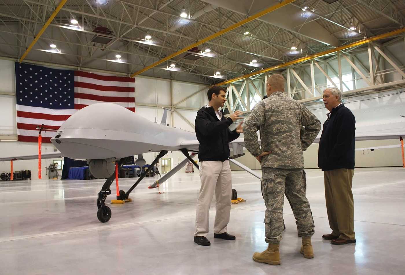 Global Security Initive affilates stand infront of a drone, showcasing the field explored in the Global Security (Irregular Warfare), MA.
