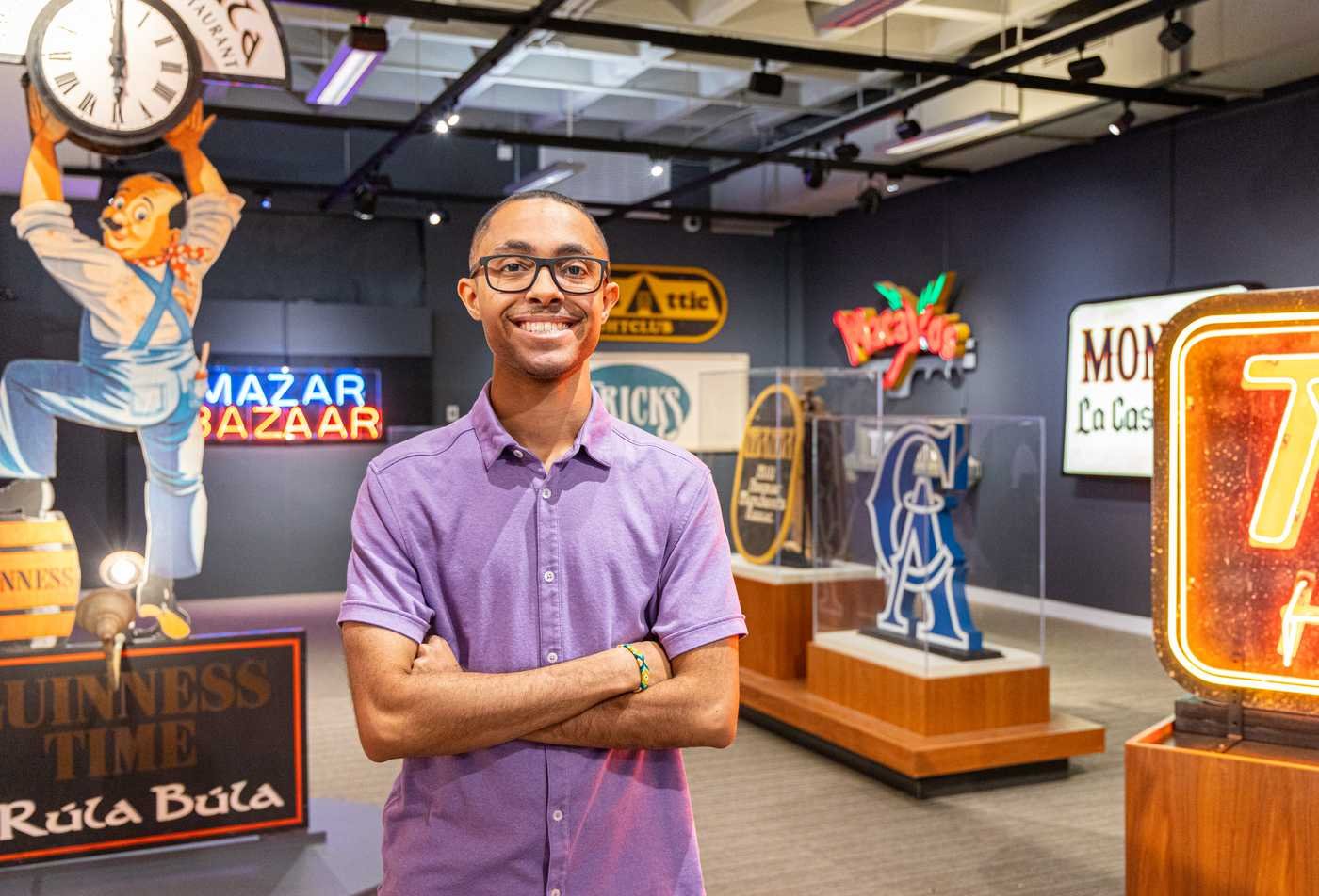 A student stands among historic signs, connecting past and present in ASU's History, BA program.
