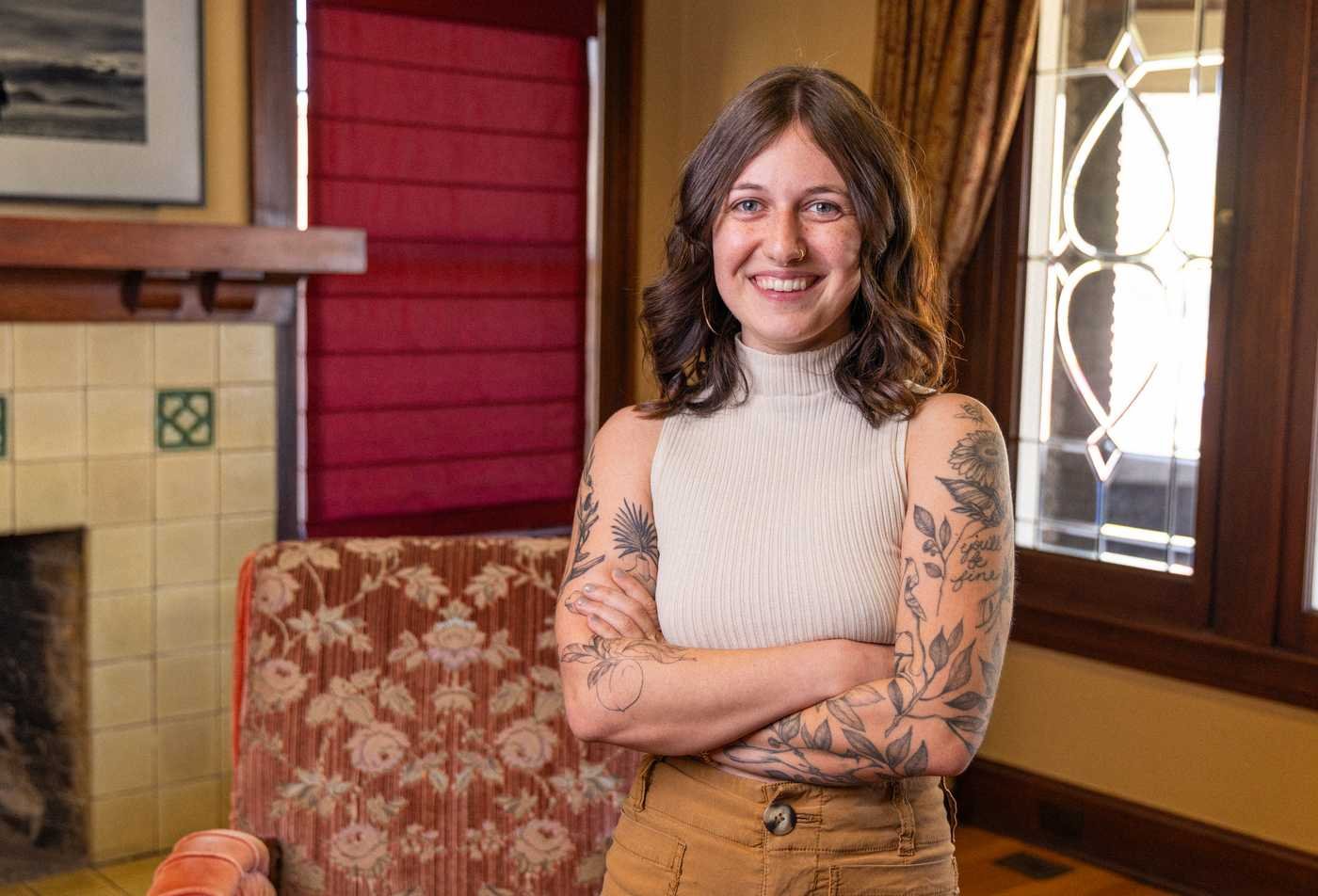 A student stands in an ornate room and smiles brightly at the camera, showcasing the expertise gained in the certificate in History and Philosophy of Science.