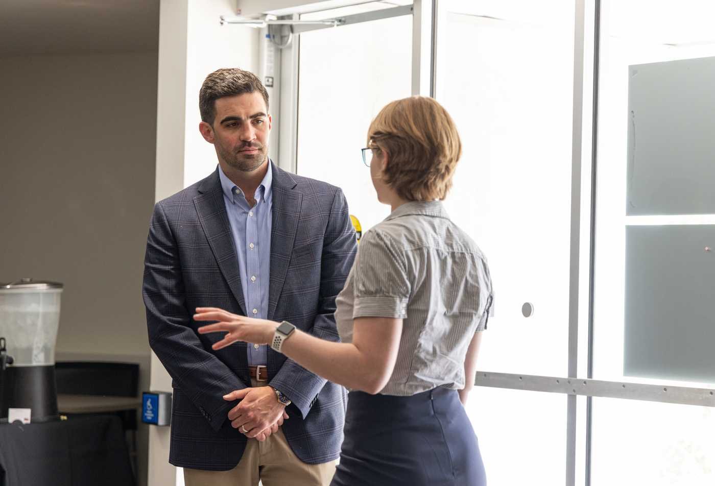 Two professionals speak at a networking event, showing the connections made during the International Affairs and Leadership, MA.