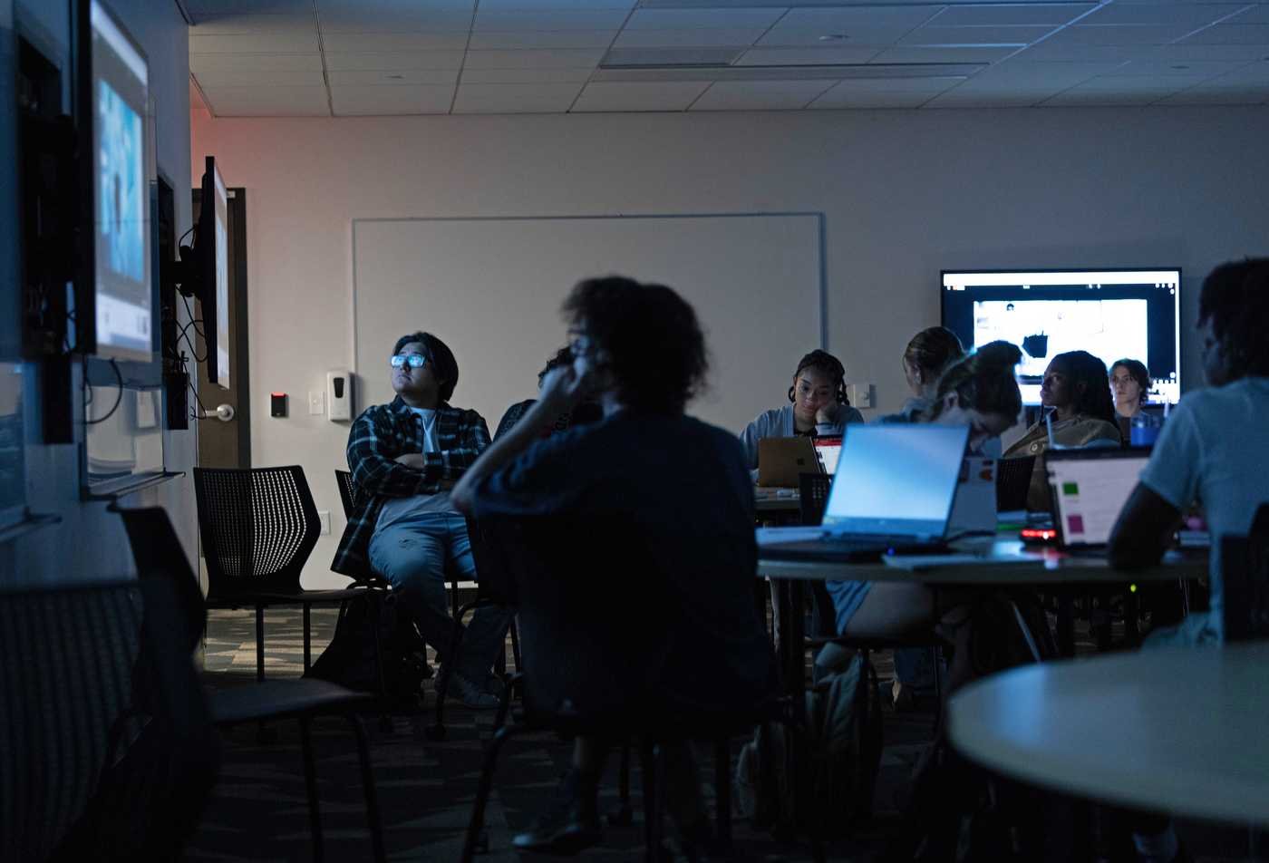 Students in a dark classroom watch a film on a projector, showcasing the activities in the certificate in International Cinema.