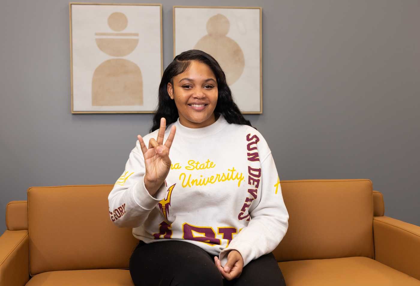 A student gestures while seated on campus, reflecting social perspectives in ASU's Justice Studies, BA program.