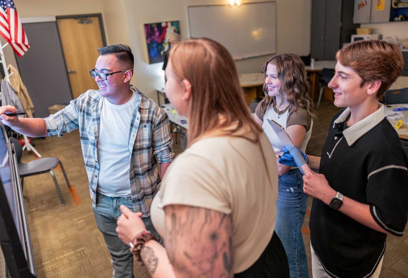 A group of students create a digital display together, showcasing the collaborative learning in the certificate in Linguistics (Graduate Certificate).
