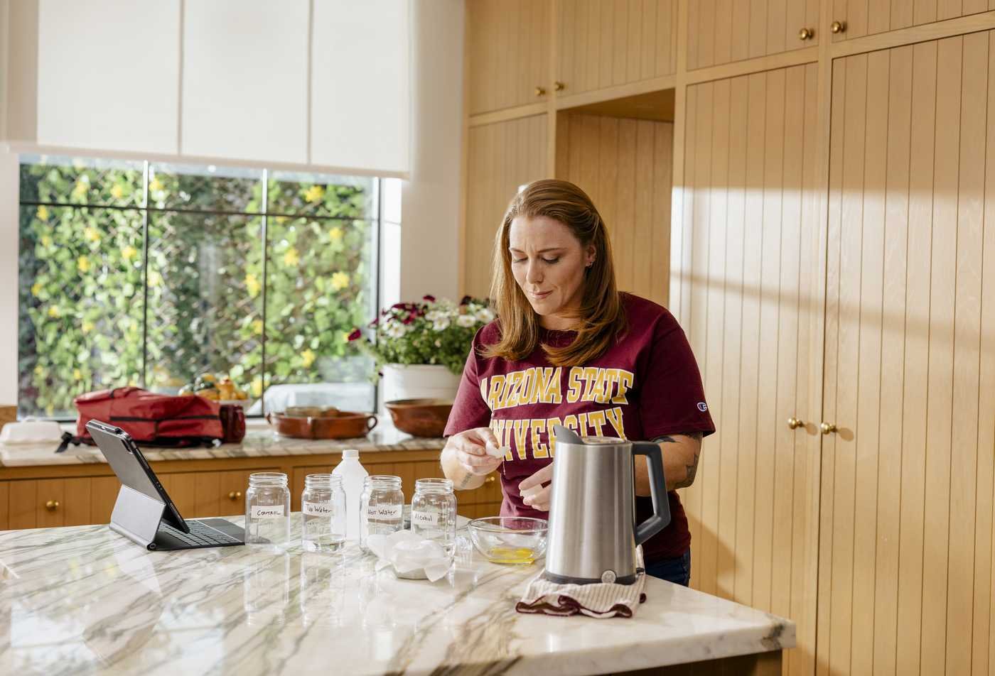An ASU student conducts a home experiment in a kitchen, showcasing hands-on learning in the Microbiology, MS.