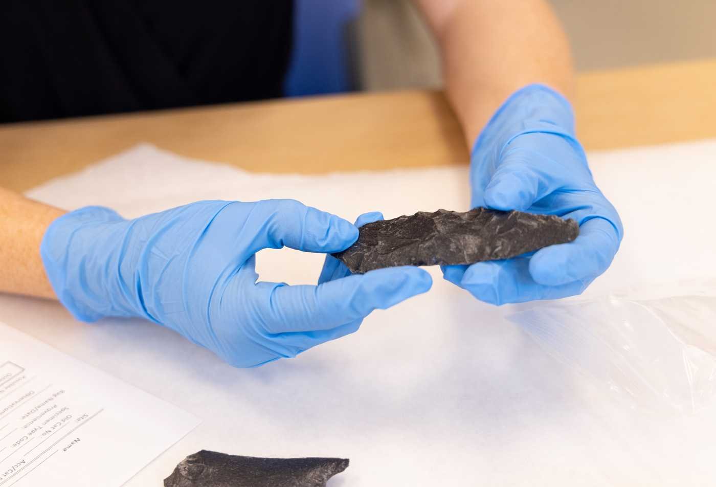 A student examines a geographical artifact, demonstrating hands-on learning in the Museum Studies, MA.