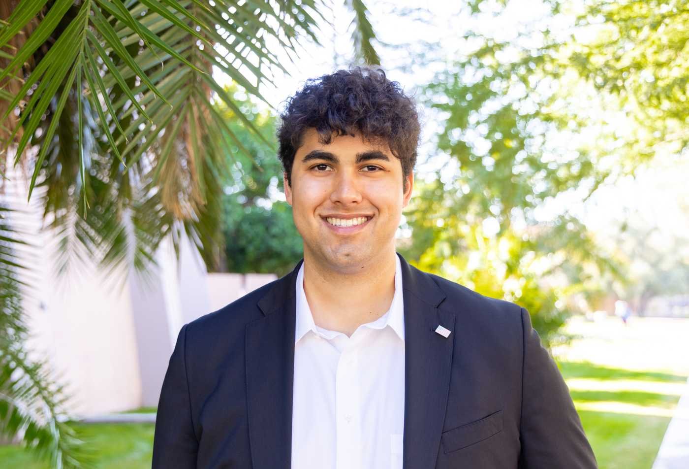 A student poses outside on university campus, symbolizing expertise gained in the certificate in Political Entrepreneurship through Internships: Local to Global.