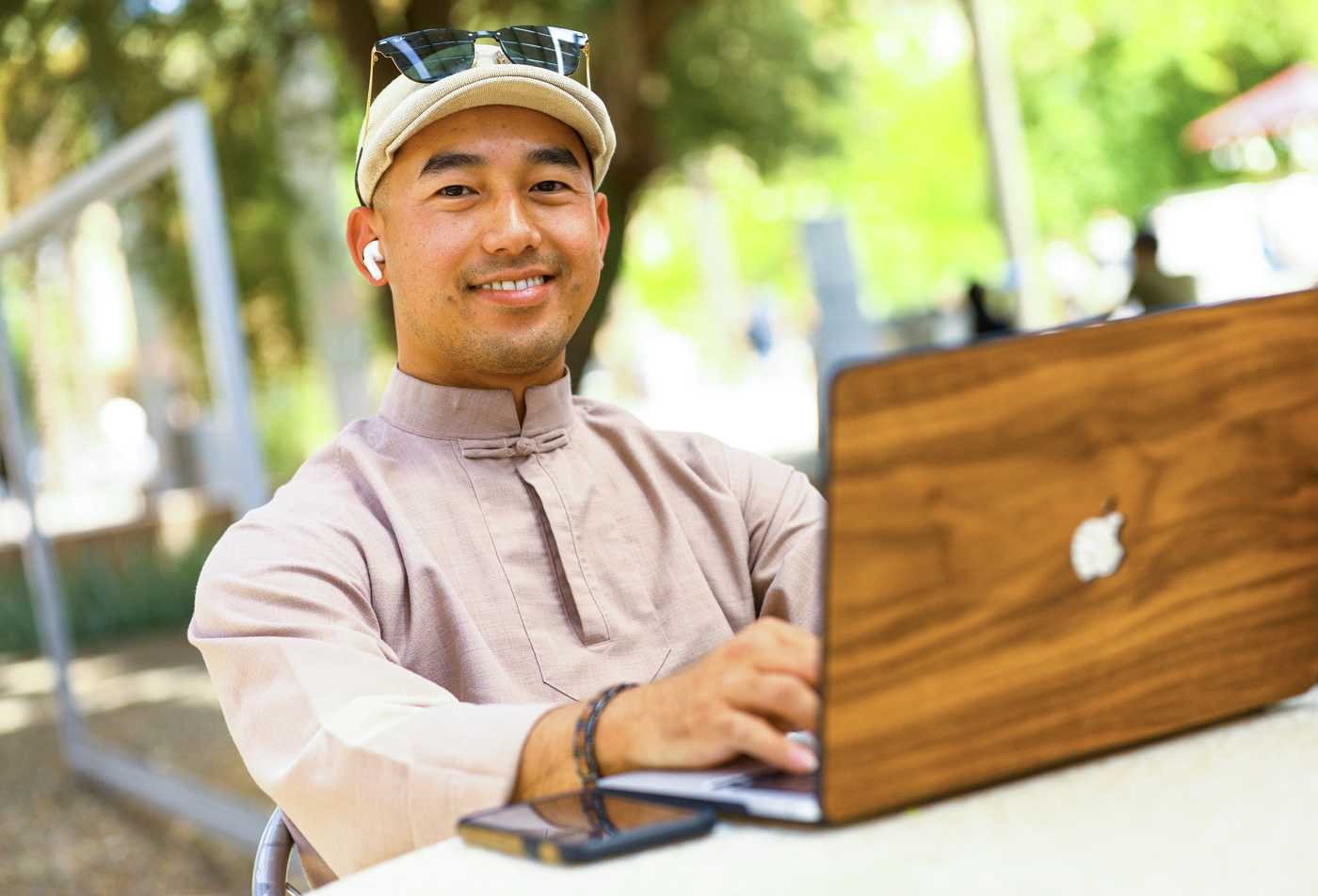 A student works on a laptop outdoors, exploring human behavior in ASU's Psychology, BA program.