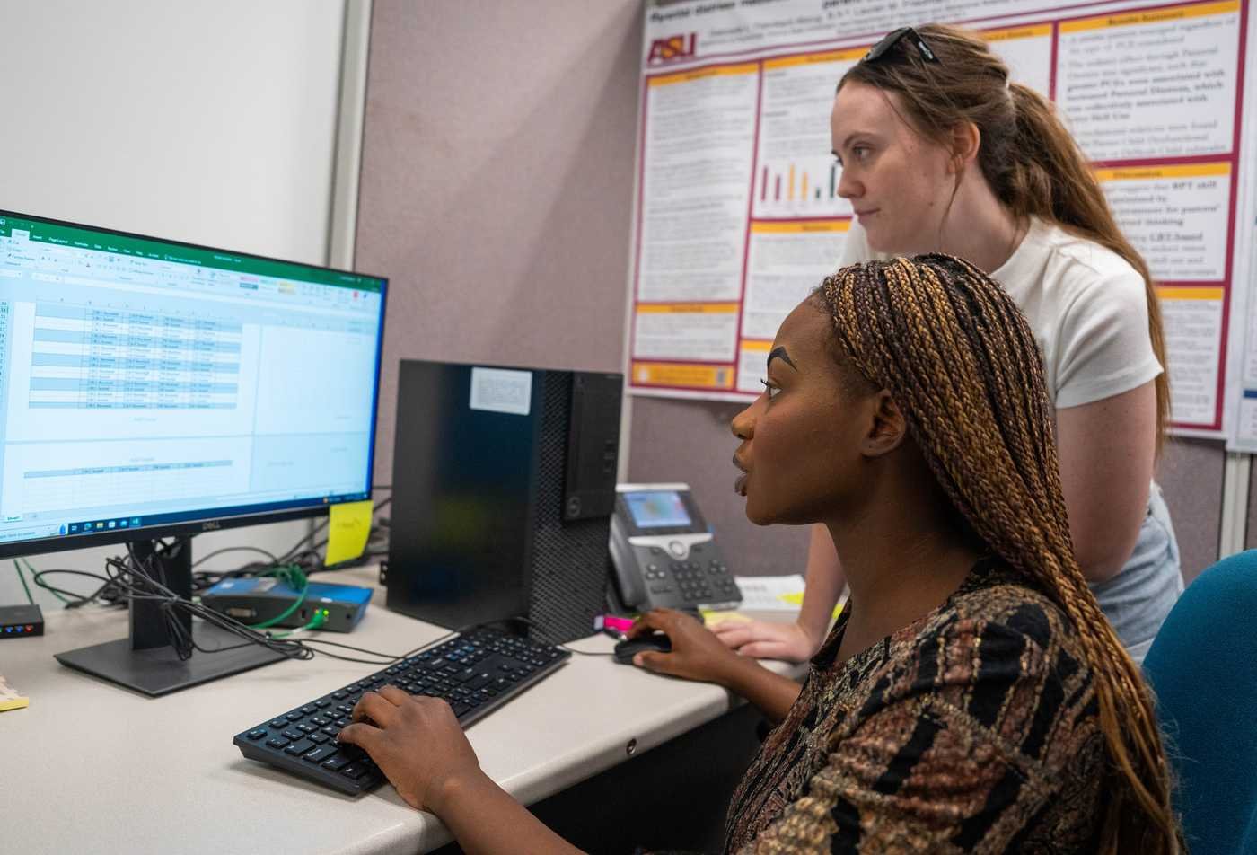 Researchers analyze data at a computer, applying behavioral research in ASU's Psychology (Psychological Science), BS program.