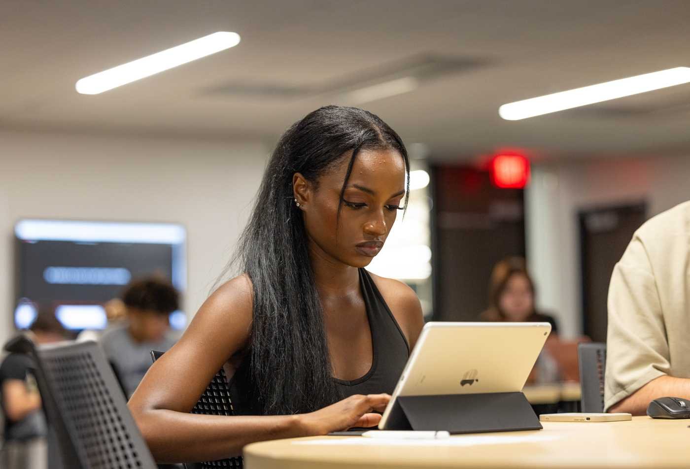 A student works on her tablet in a classroom, demonstrating flexible learning in the minor in Political Science.