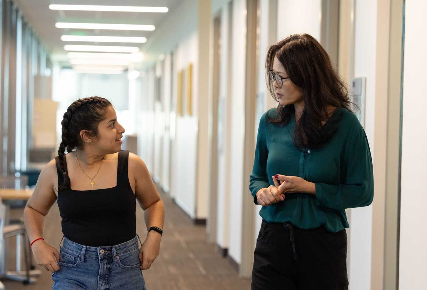 A student discusses social impact with a professor, showcasing personalized learning in the Social and Cultural Pedagogy, MA.