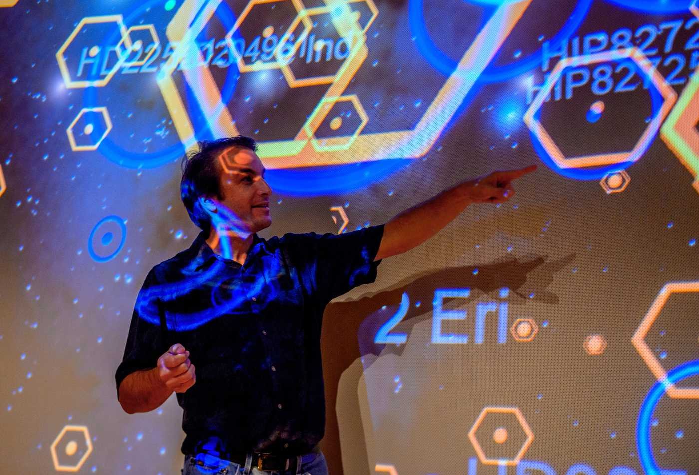 A researcher presents cosmic data on a large display, exploring the universe in ASU's Earth and Space Exploration (Astrophysics), BS program.