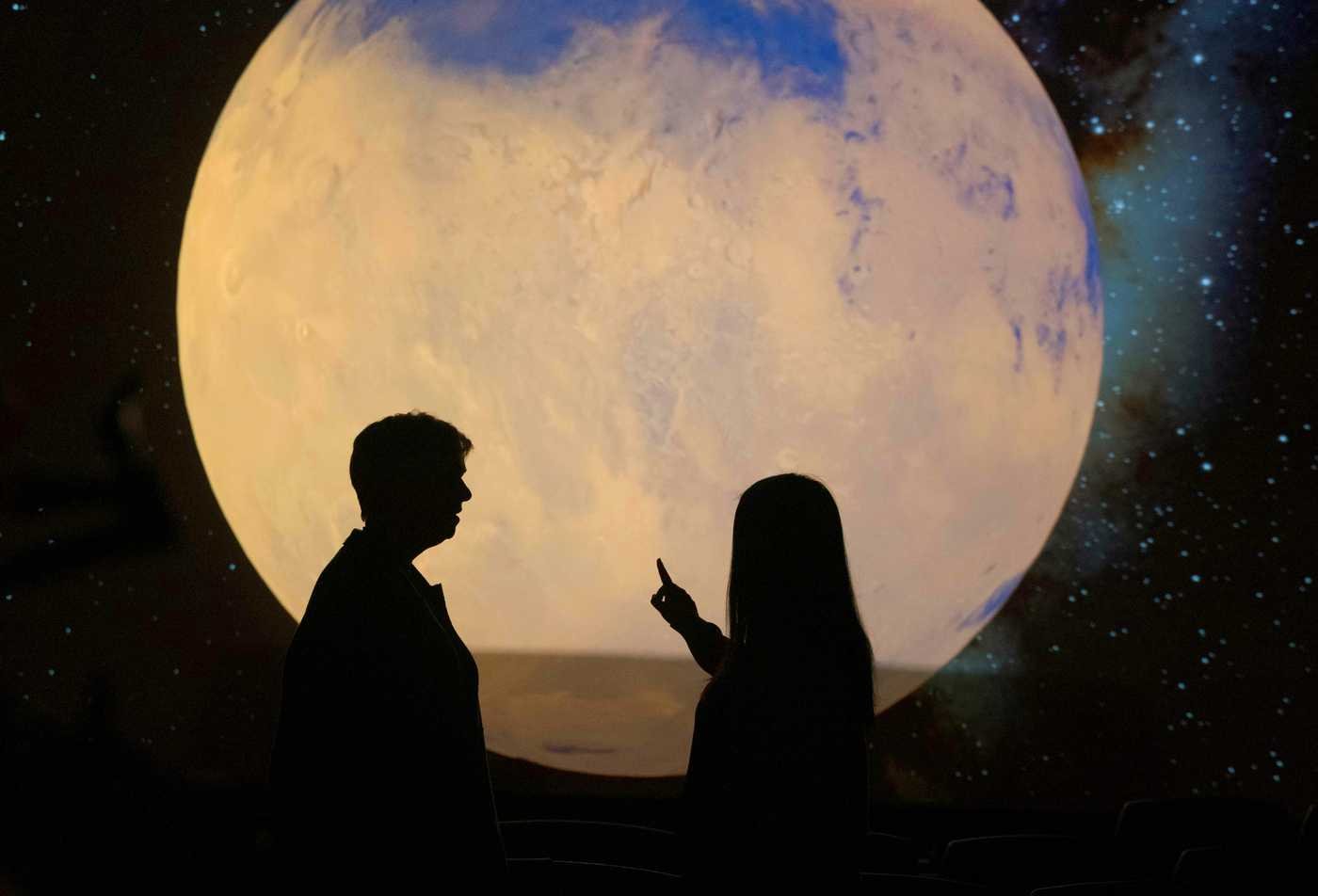 Two people discuss a planetary display, exploring the cosmos in ASU's Earth and Space Exploration, BS program.