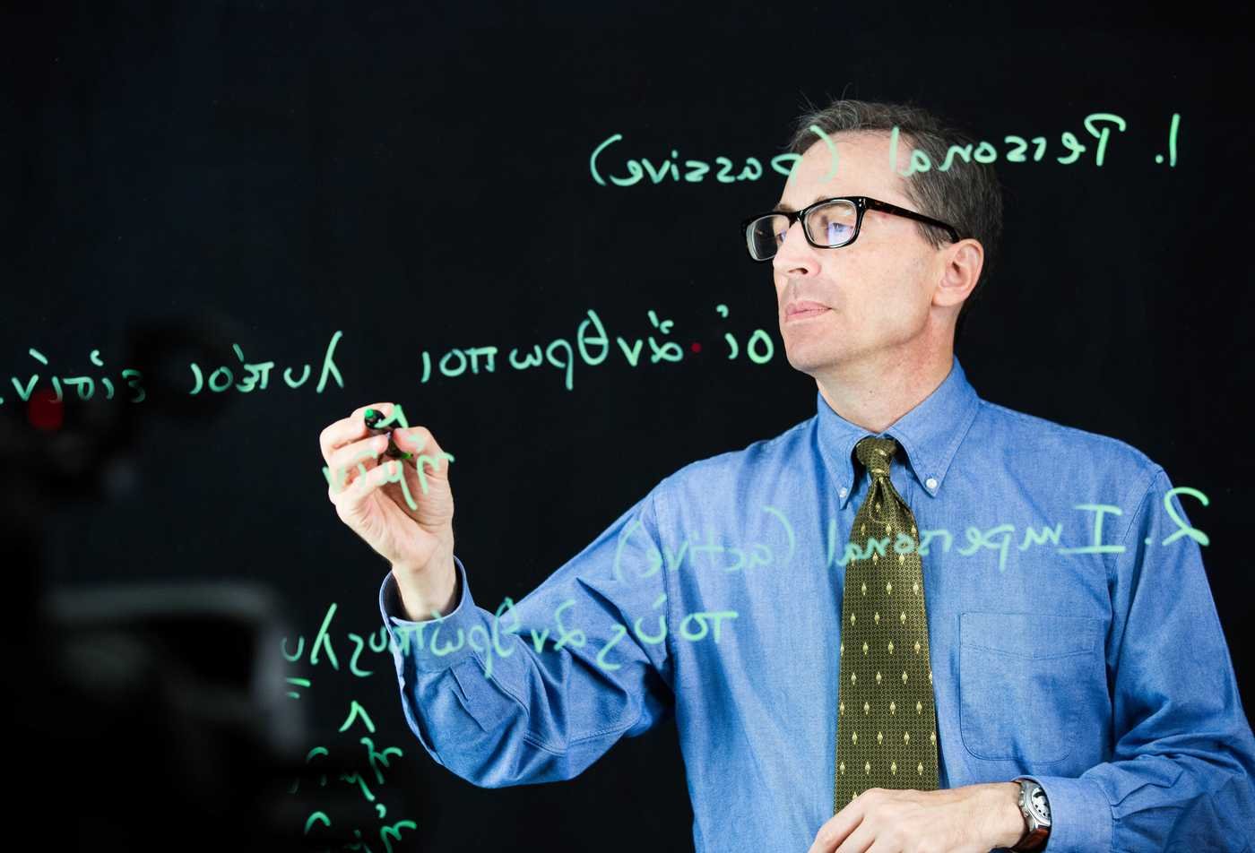 A professor writes on a glass board, exploring classical language in ASU's International Letters and Cultures (Classics), BA program.