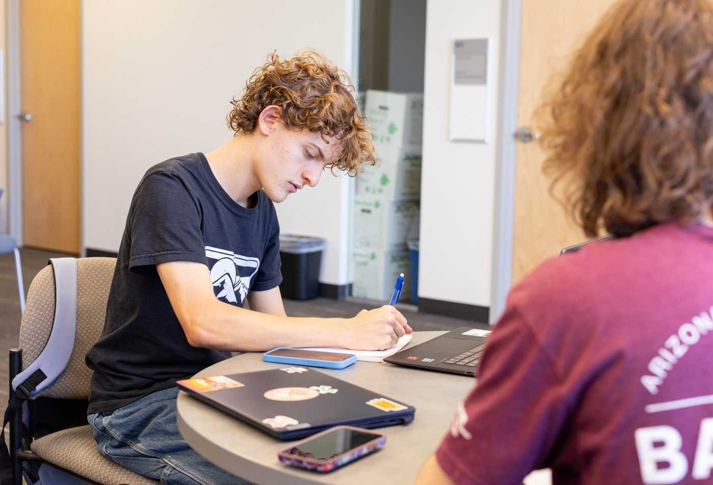 Students study together at a table, showcasing collaborative learning in the certificate in Socio-Legal Studies.,