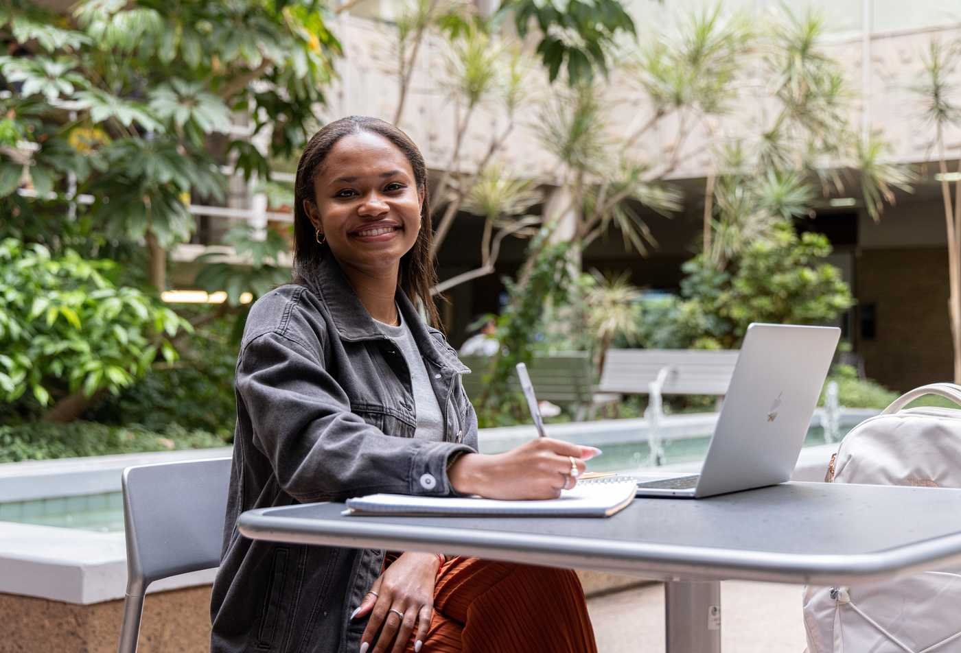 A student studies outdoors on campus, showcasing flexible learning in the minor in Sociology.