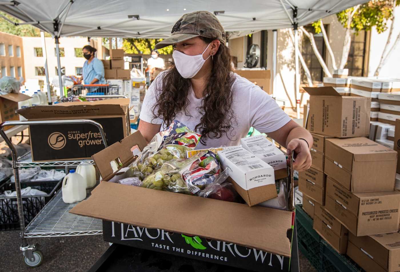 A volunteer sorts fresh food for distribution, reflecting community well-being in ASU's Global Health, BA program.
