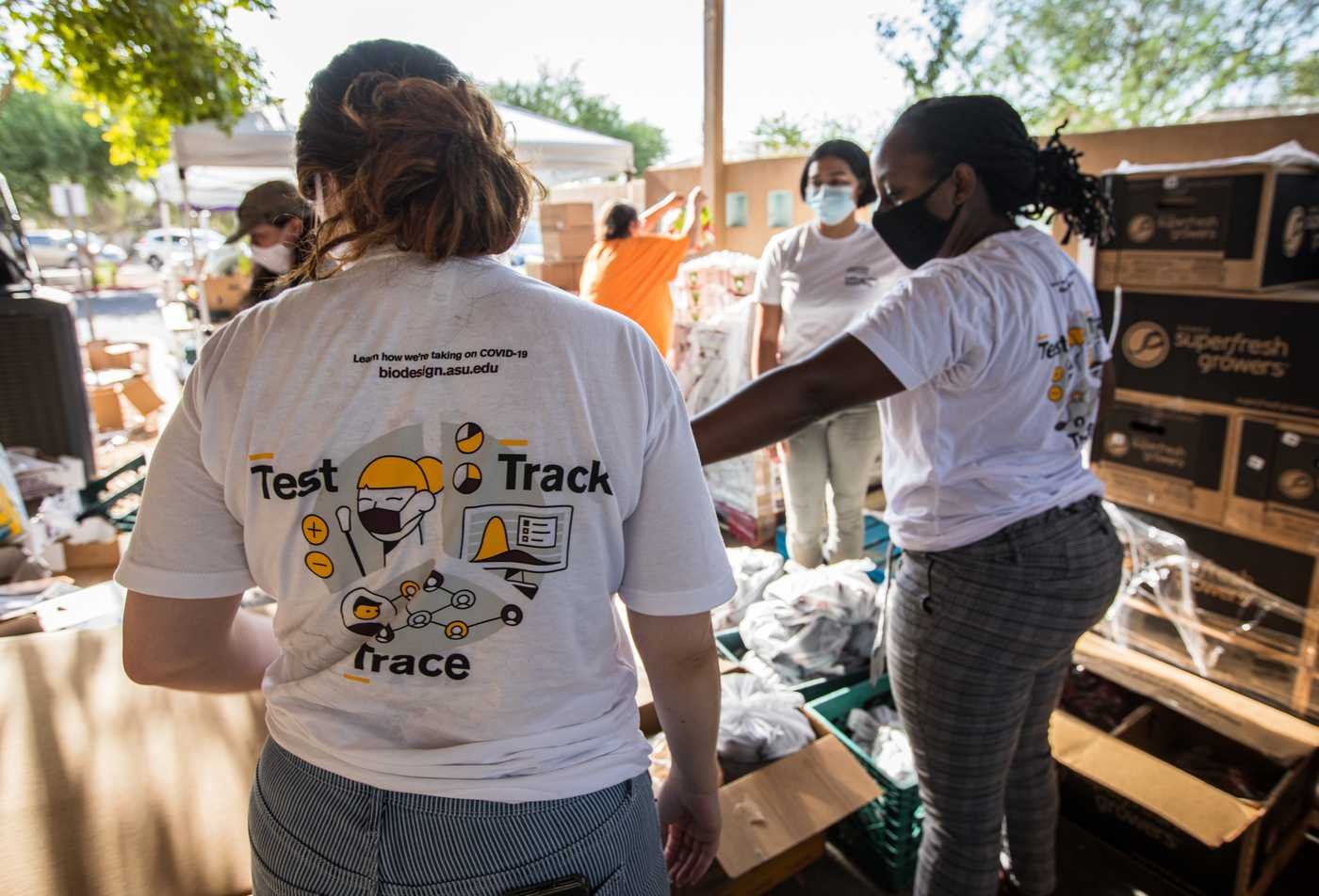 Students pass out food during a community event, reflecting the community-well being in the minor in Global Health.