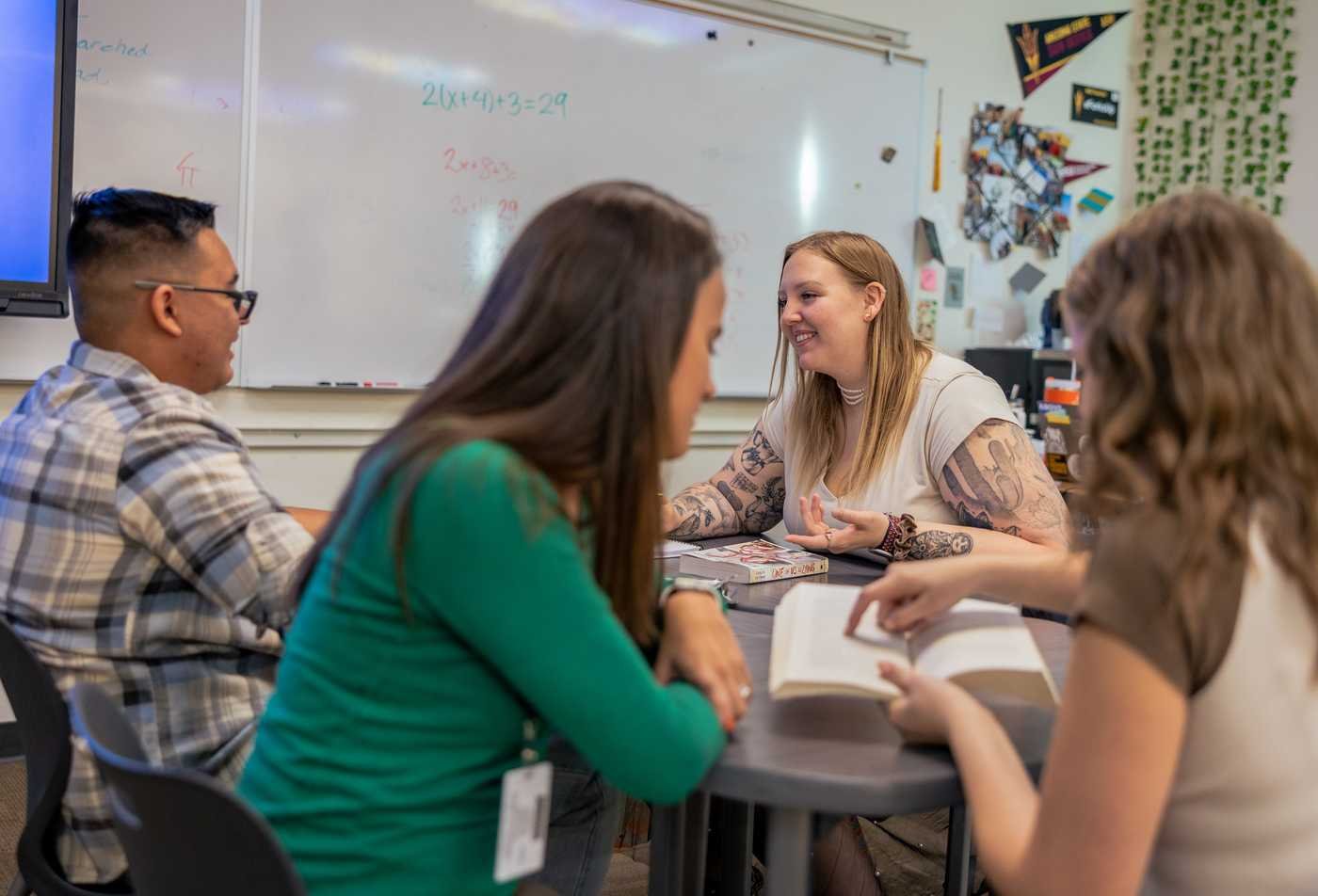 Four students work together in a classroom, showcasing collaborative learning in the certificate in Teaching English to Speakers of Other Languages (TESOL).