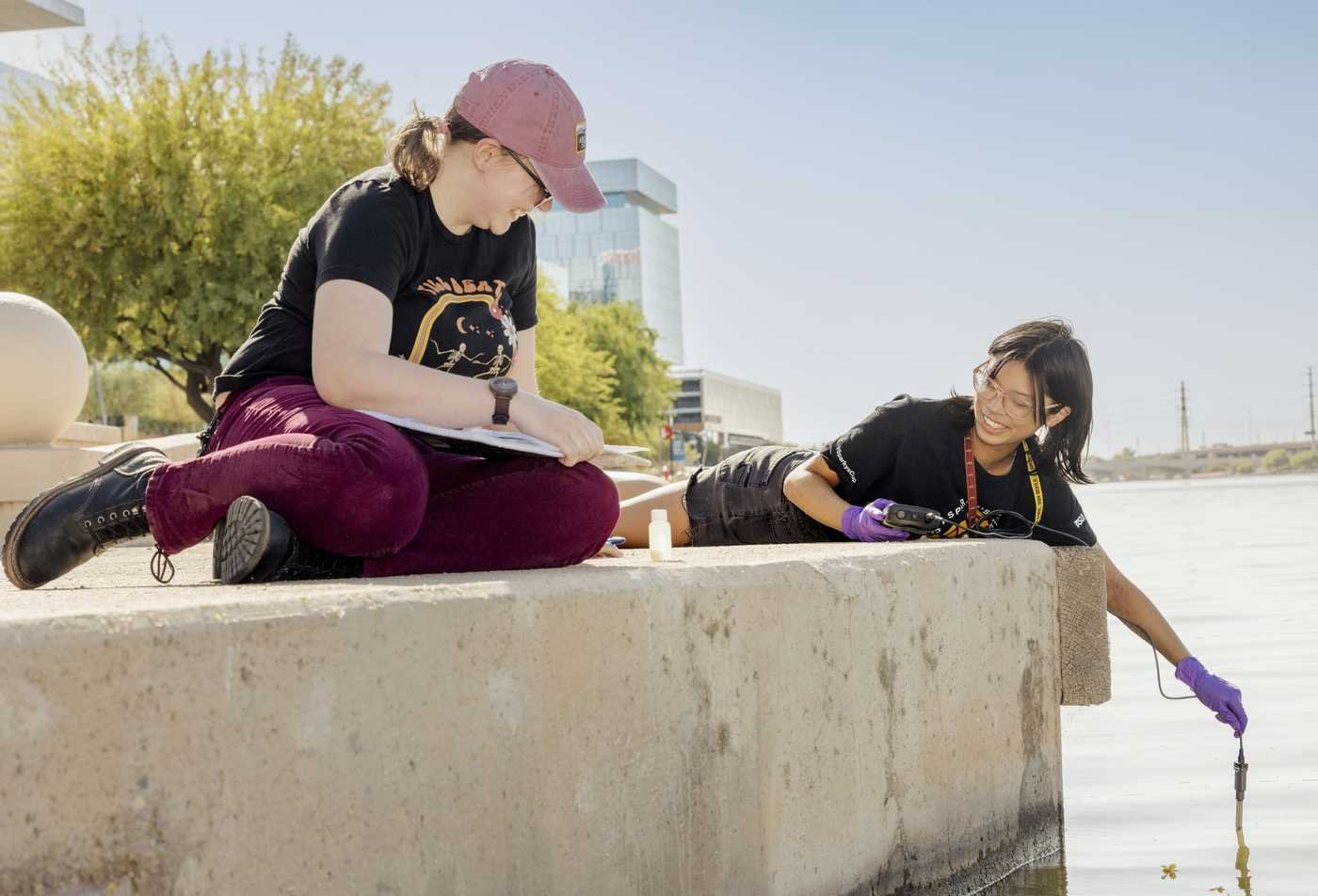 Two students analyze water quality at Tempe Town Lake, demonstrating hands-on learning in the Water Resources.