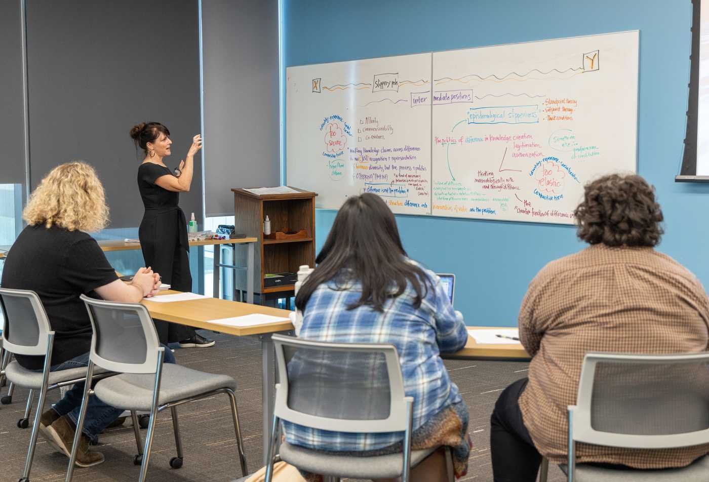 Students looking at the board while teacher is teaching a gender studies class