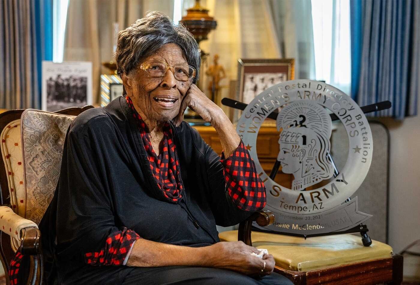 A veteran poses beside a Women's Army Corps emblem, reflecting service history explored in ASU's Military and Veterans Studies certificate.