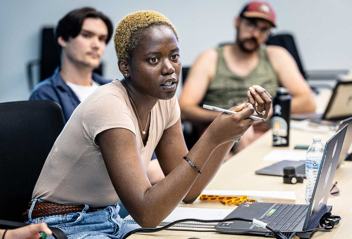 Students discuss ideas around a laptop, exploring society through ASU's Integrative Social Science, BS program.