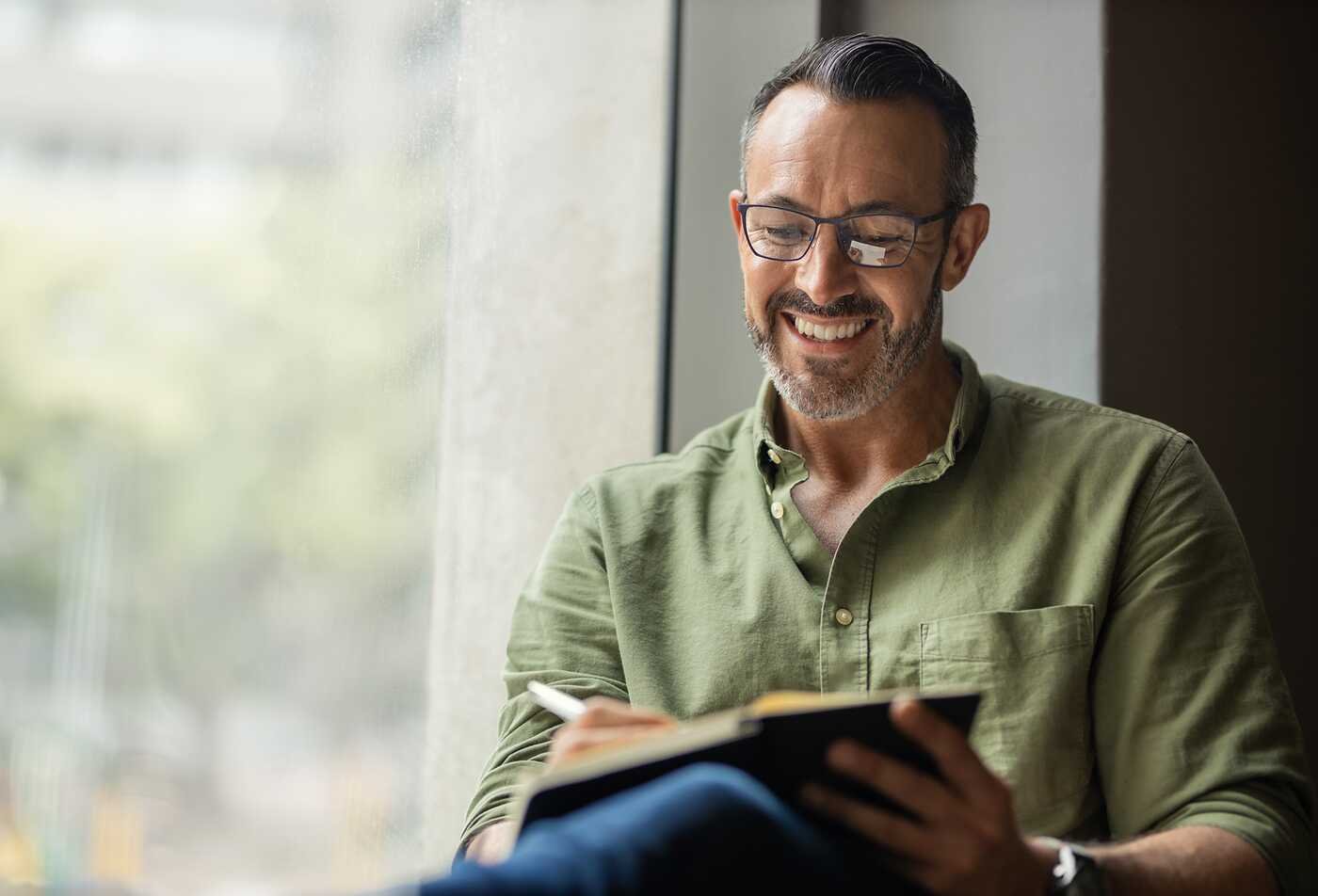 A writer works in a notebook, reflecting advanced storytelling and analysis in ASU's Narrative Studies, MA program.