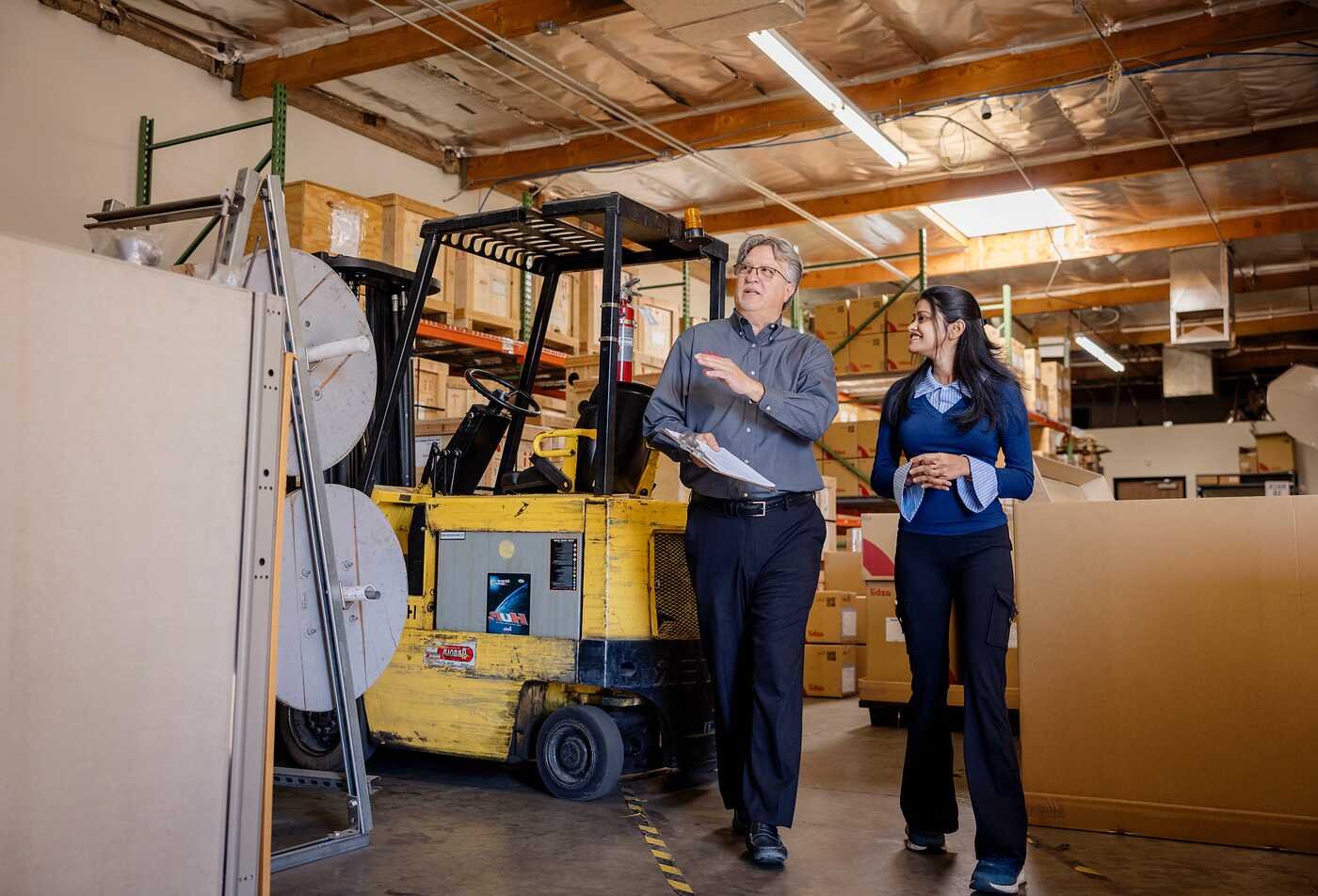 Professionals discuss operations in a warehouse, reflecting strategic management in ASU's Organizational Leadership, MS program.